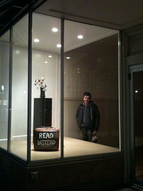 A storefront window with a suitcase reading 'READ INSTEAD'
